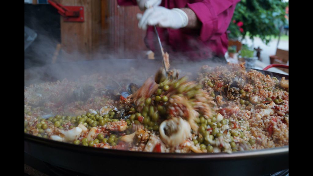 Paella in großer Pfanne wird umgerührt, Spain Live bei Fortes